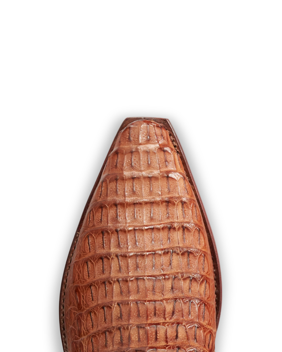 Close-up of the pointed toe of The Garrett Hornback Caiman shoe in pecan, featuring an embossed crocodile skin pattern, viewed from above against a white background.