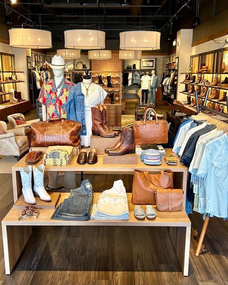 Interior of a boot store with shelves of various styles of cowboy boots, highlighting different patterns and colors, in a well-lit wooden display.
