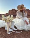 Bride in the desert kneeling next to a pair of Sadie's in Snow Ostrich