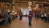 People in dancehall two stepping across wood floor