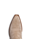 Close-up of the toe of a beige suede cowboy boot with stitch detailing, isolated on a black background.