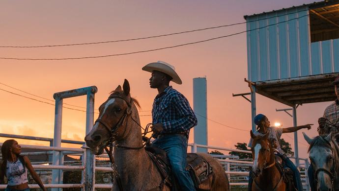 cowboys on horses in sunset