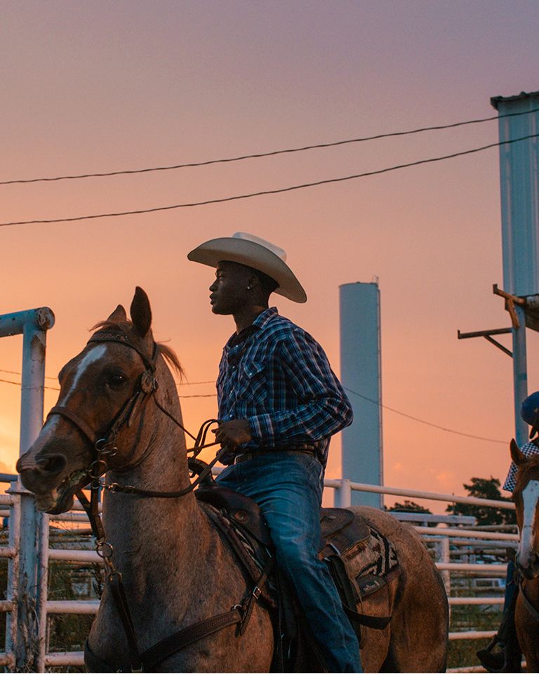 cowboys on horses in sunset