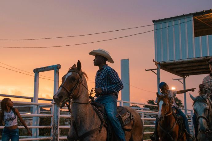 cowboys on horses in sunset