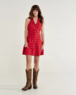 Woman wearing a short dress and brown cowgirl boots in a photo studio