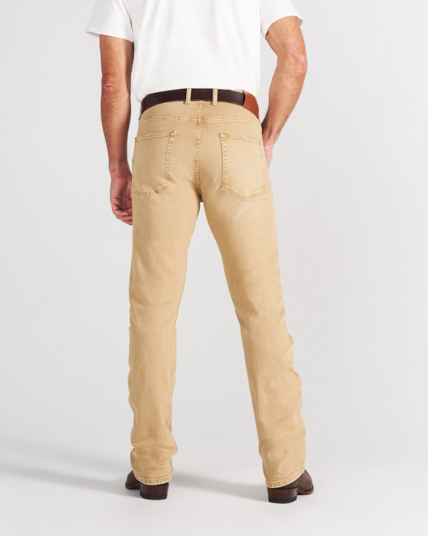 Back view of a person wearing a white t-shirt, brown belt, tan jeans, and brown leather boots.