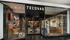 A glass storefront displays the Tecovas store, featuring boots, leather goods, and western-themed decor inside a shopping mall.