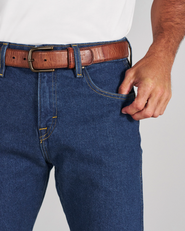 A person wearing a white t-shirt, blue jeans, and a brown leather belt, with their hand resting near a front pocket.