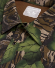 Close-up of a button-down shirt with a green and brown camouflage pattern and a visible label reading "Performance Western Shirt, Modern Fit, L.