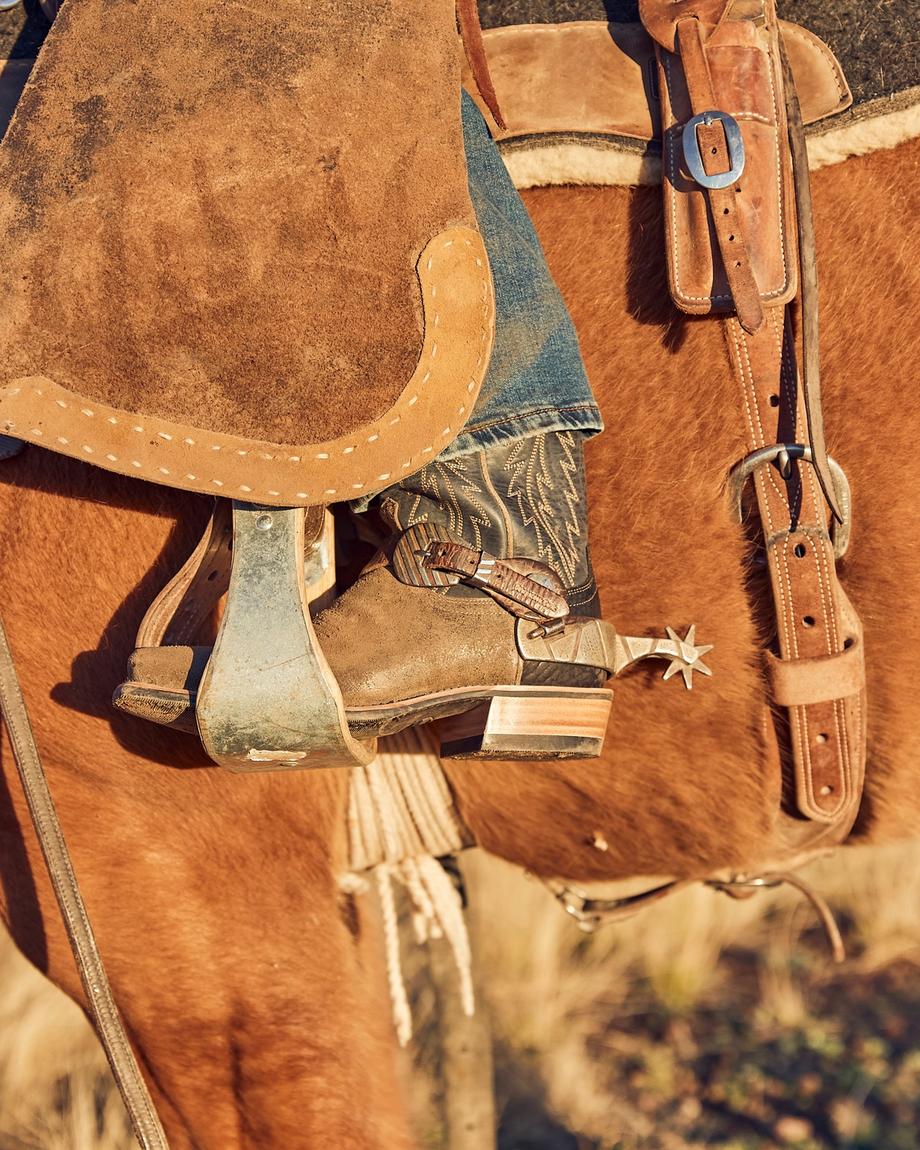 Closeup of The Parker worn by a cowboy who is riding a horse