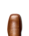 Close-up of a brown cowboy boot with detailed stitching on the toe, against a plain black background.