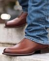 close up picture of Earl bourbon brown cowboy boots on a man's feet