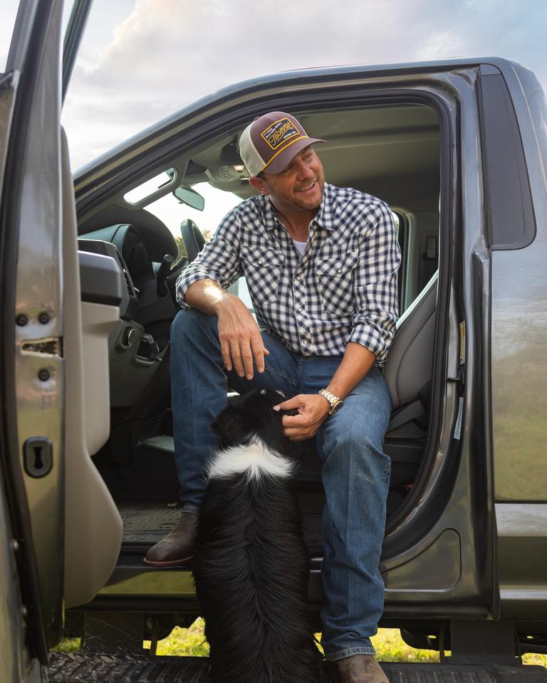 A man in a truck with a dog