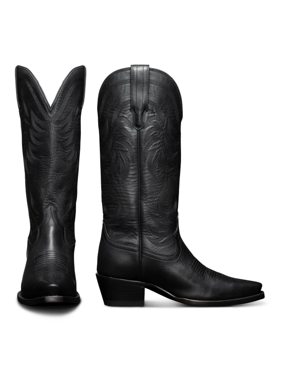 Two black cowboy boots with intricate stitching patterns are shown; one boot is seen from the side and the other from the back.