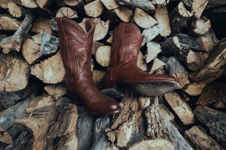 pair of brown cowboy boots on wood