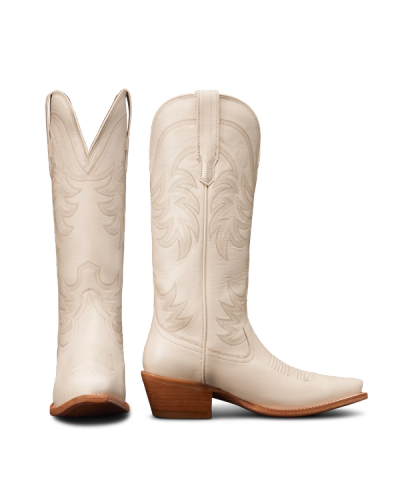 Two white cowboy boots with decorative stitching, showing side and rear views. They have brown stacked heels and pointed toes.