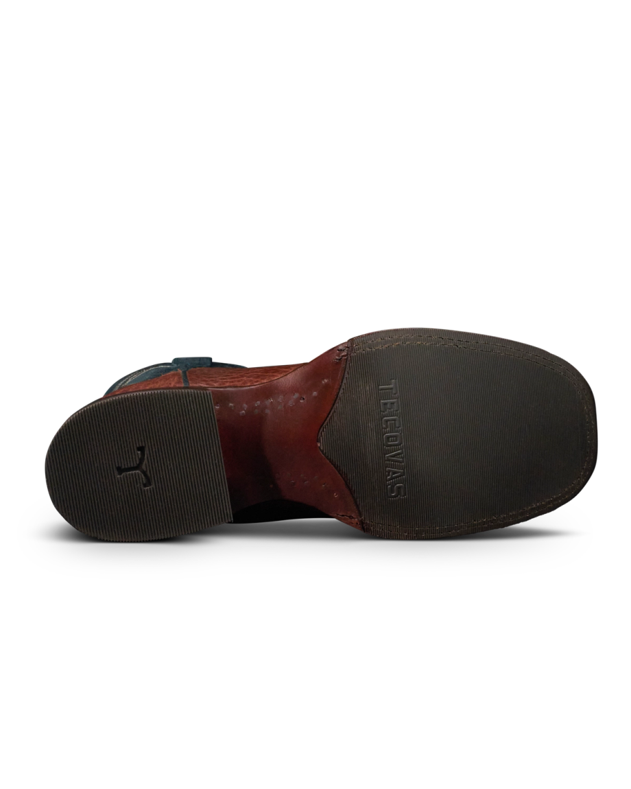 The Doc in Burnt Umber / Blue Cowhide. The image shows the sole of a formal shoe, crafted from fine cowhide and featuring a textured heel and toe area, with "TED BAKER" embossed on the front half.