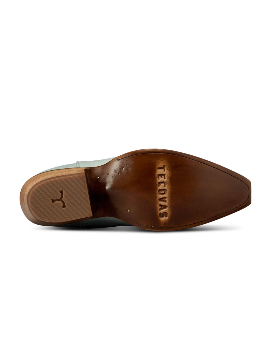 The Annie in Slate Blue Cowhide. Bottom view of The Annie Cowhide boot sole in brown leather, featuring the Tecovas brand name and a small bull logo near the heel.
