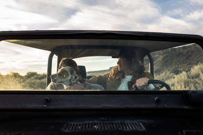 couple in a car with a dog