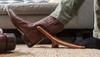 Image of man taking off boot using a boot jack