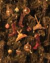 Christmas tree decorated with gold lights, cowboy boot ornaments, cowboy hat ornaments, and various round baubles.