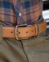 Close up of a caramel colored bovine belt around a man's waist