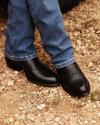 Image of man wearing the cartwright midnight on gravel at a ranch