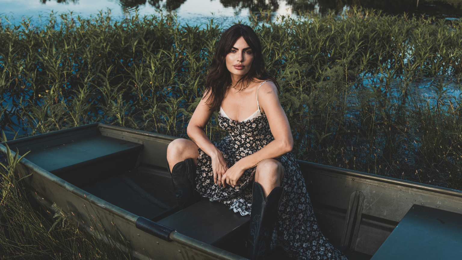 woman, boat, cowboy boots, on a lake