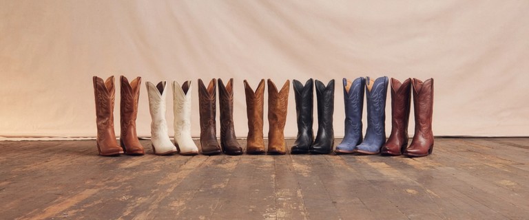 Seven pairs of Annie cowgirl boots in different colors in a line