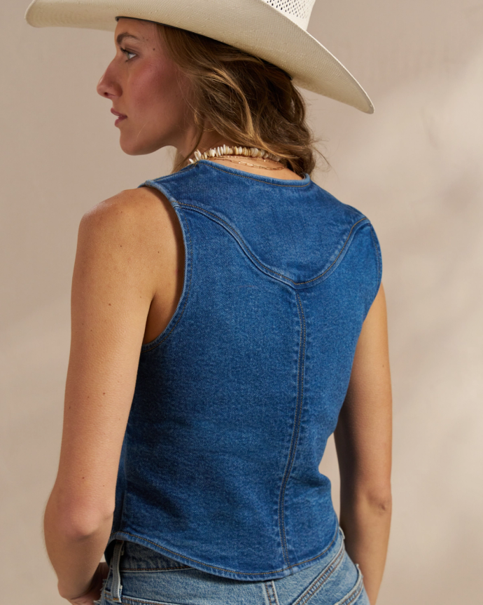 View of the back of the Women's Denim Vest in the color medium wash.