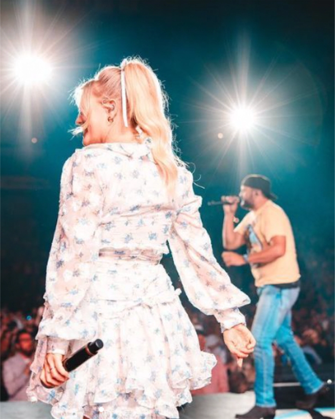 A man and a woman singing at a concert.