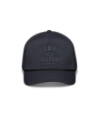 A black baseball cap with the text "Tecovas Quality Made Western Austin, Tex." on the front. It features a mesh back and a rope across the brim.