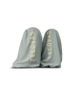 The Annie in Slate Blue Cowhide. Two light gray boot bags with "Tecovas" printed in large yellow letters on each, placed side by side against a plain white background.