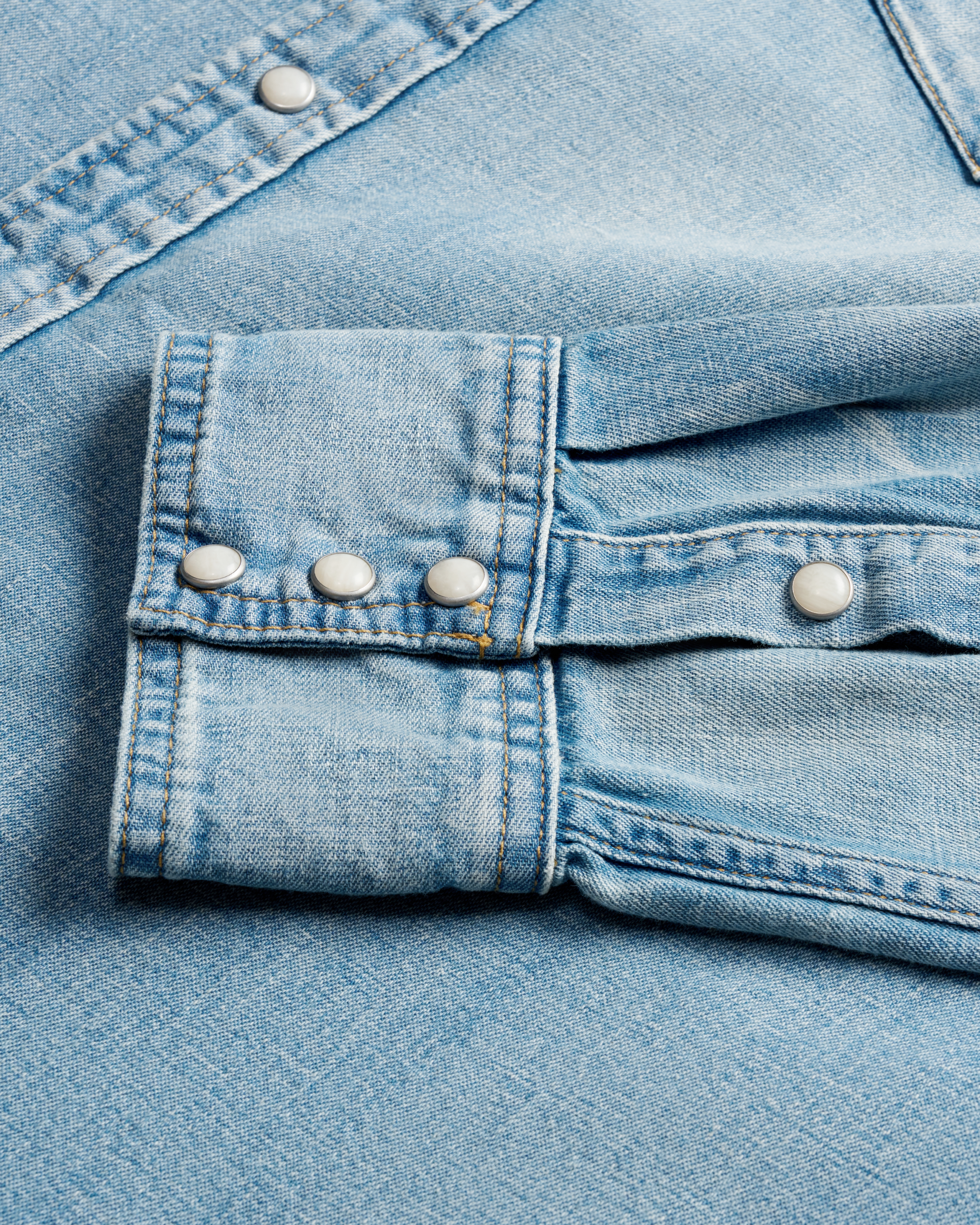 Closeup detail view of Men's Denim Pearl Snap LS - Light Wash