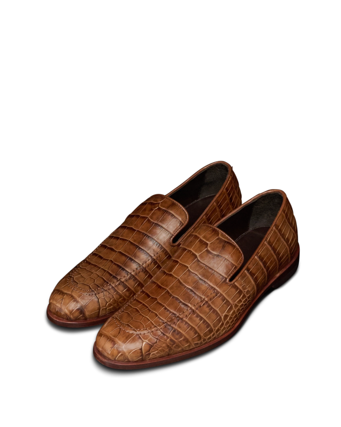 The Bennett in Saddle Alligator. A pair of brown alligator-patterned leather loafers with rounded toes and low heels, displayed on a white background.
