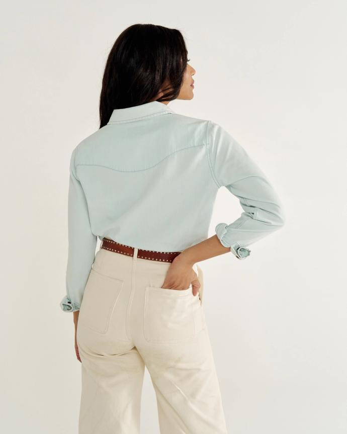 Person in light blue shirt and beige pants, facing away.