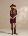 Woman wearing a short dress and brown cowgirl boots in a photo studio