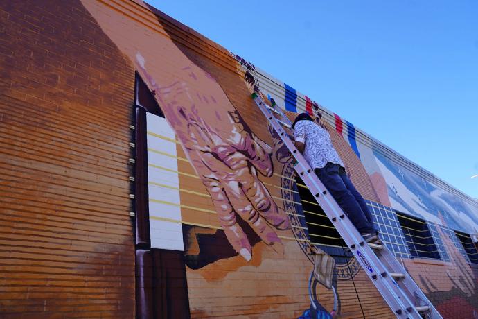 angled view of the mural of Willie Nelson hand playing guitar