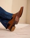 Person sitting wearing the Tecovas Chance boots.