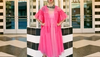 Woman in a pink dress and white hat wearing white cowgirl boots