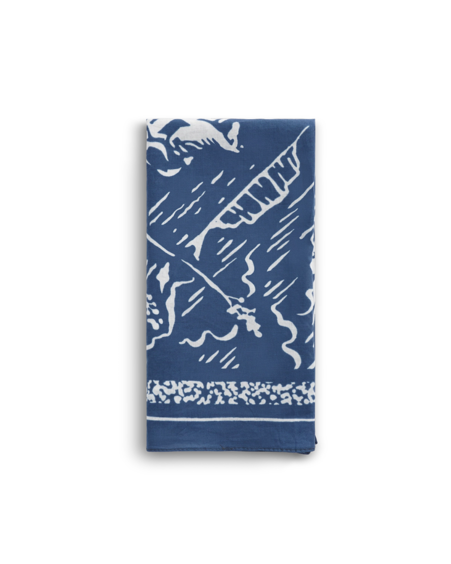 A folded blue and white cloth napkin featuring an abstract pattern with leafy and wavy designs.
