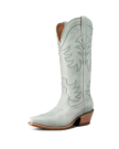 The Annie in Slate Blue Cowhide. Light gray, tall cowboy boot with decorative stitching, a pointed toe, angled heel, and side pull tabs, photographed on a white background.