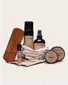 A collection of Tecovas shoe care products, including a brush, sprays, wax, tins, and cloths, arranged neatly against a plain background.