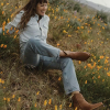 Woman wearing The Daisy bootie in a field