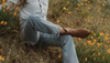 Woman wearing The Daisy bootie in a field