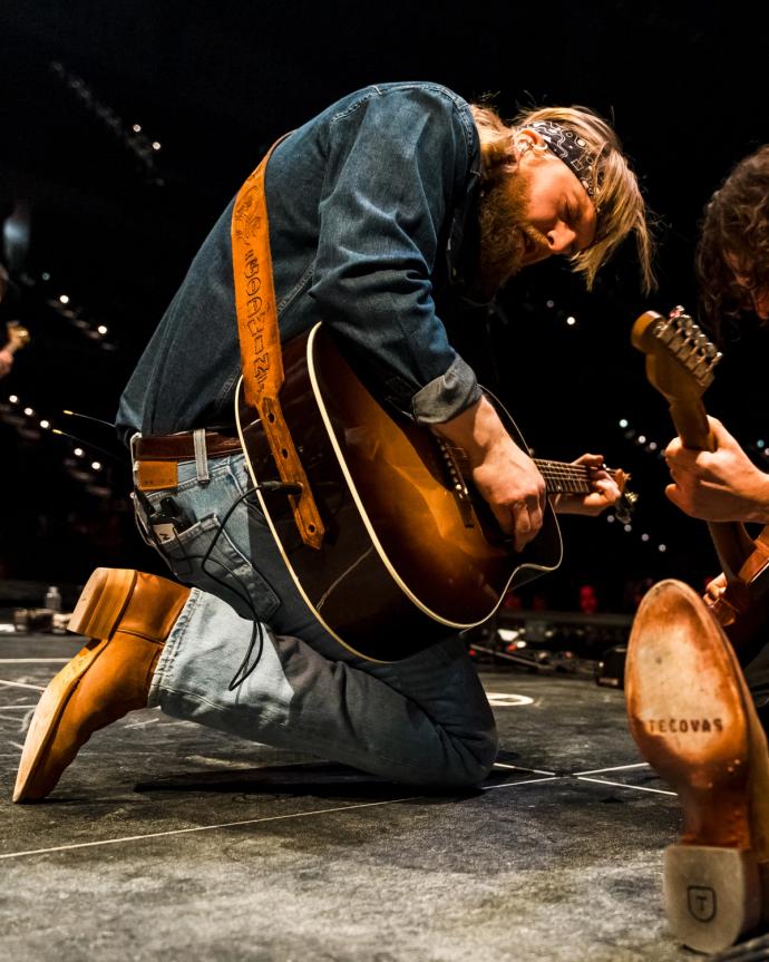 Charles Wesley Godwin performing with a guitar on stage.