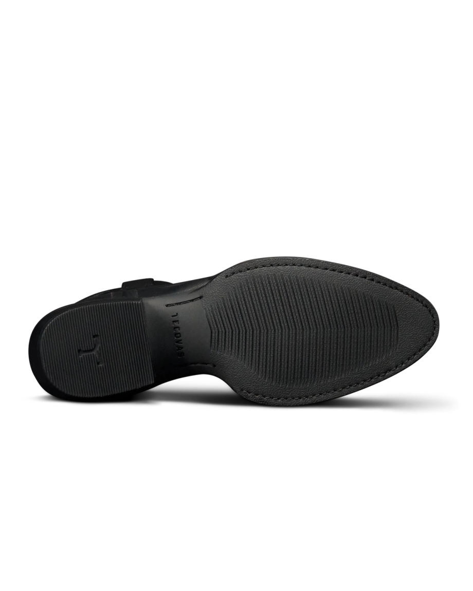 The Britt in Midnight Cowhide. The image shows the black rubber sole of The Britt Cowhide dress shoe, viewed from the bottom, featuring textured grip patterns and subtle branding near the heel.