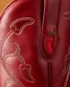 Close-up of red leather with chili pepper embroidery and stitching detail, possibly part of a cowboy boot or western-style accessory.