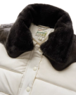 Close-up of a white puffer jacket with dark faux fur collar, brown shoulder accents, snap buttons, and a Tecovas branded label inside the neck area.