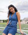 Woman at a football field wearing the Women's Denim Vest in the color medium wash.